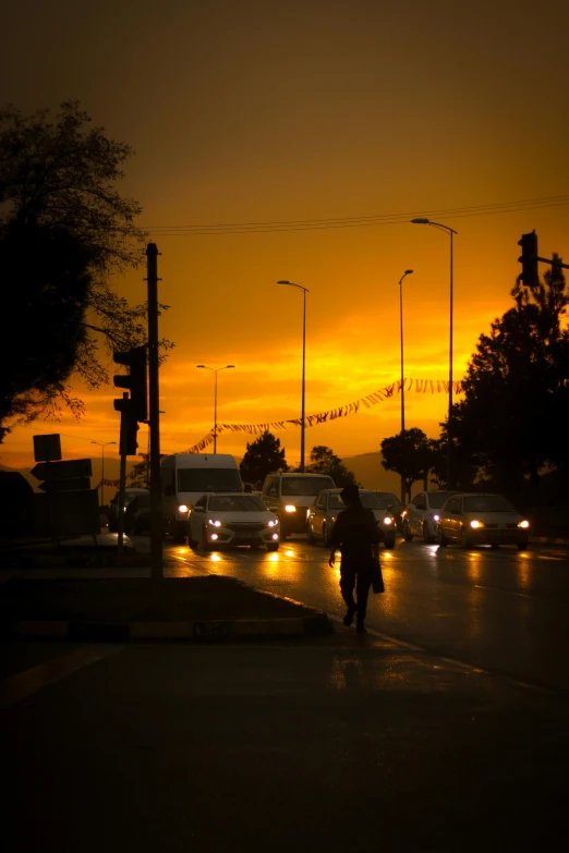 a man walking down a street next to the road light