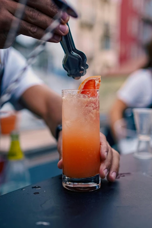 the bartender is filling his glass with a cocktail