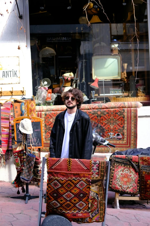 a man is holding an old carpet in front of a store