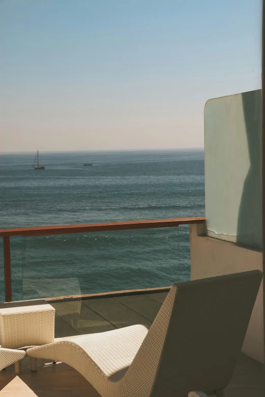 two chairs on the patio looking out at the ocean