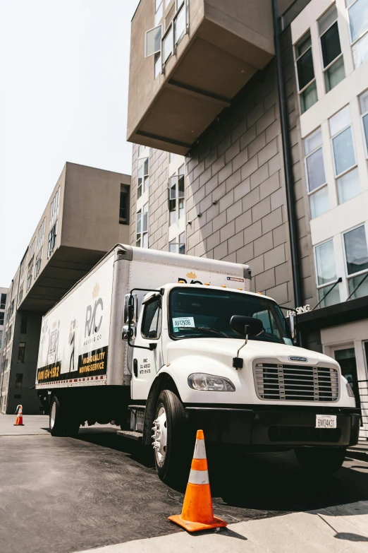 a big truck is parked in front of a tall building