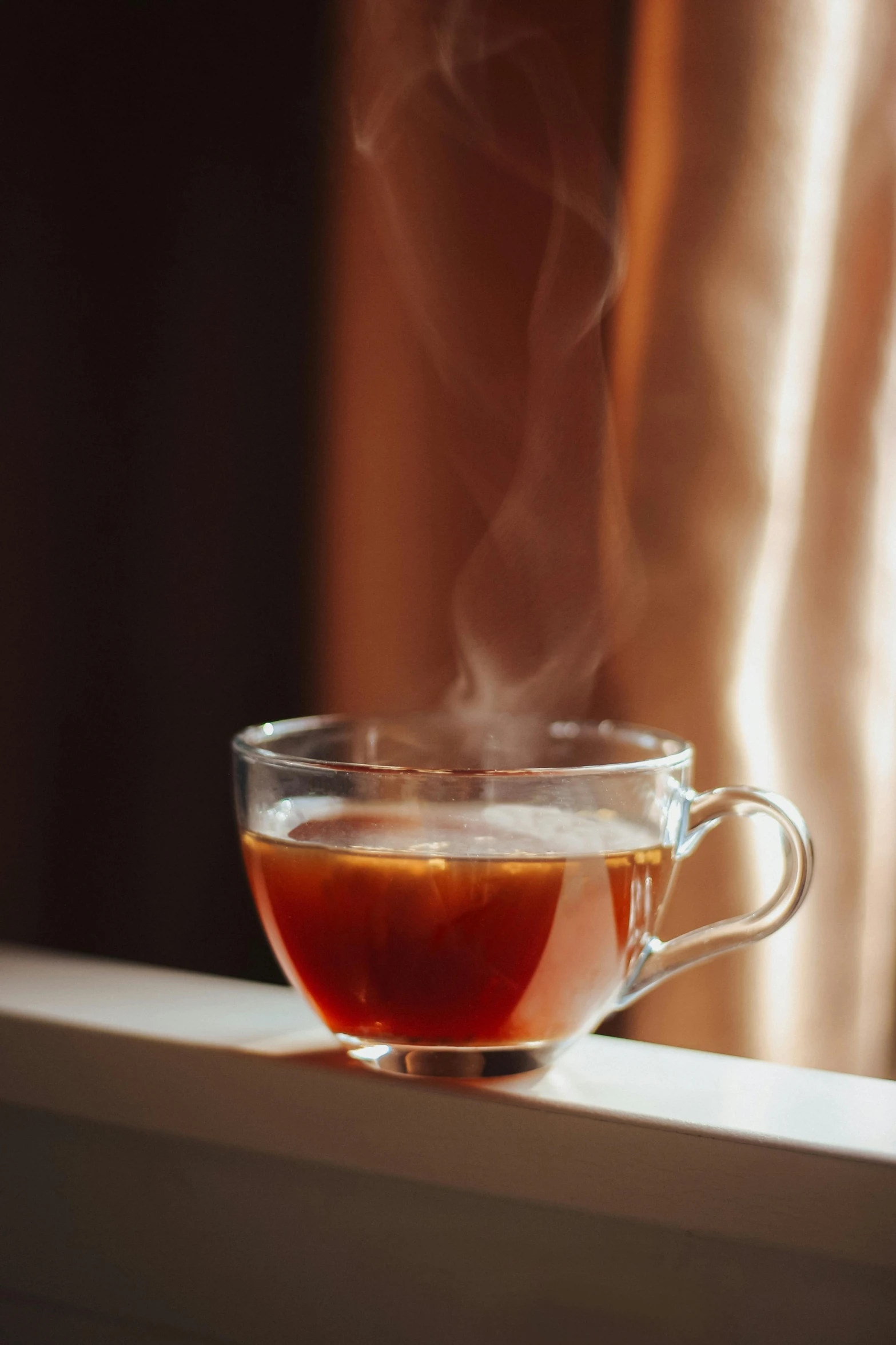 a glass cup filled with coffee sitting on a counter