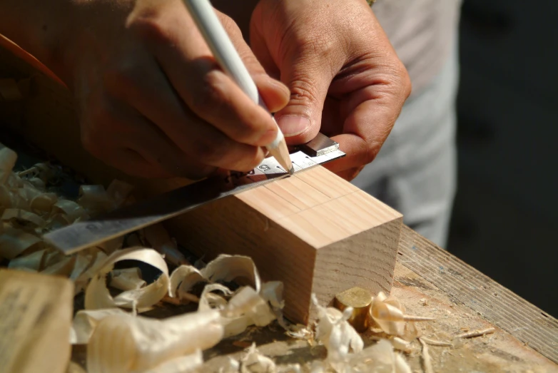 a man with a wooden pencil and  soing on a board