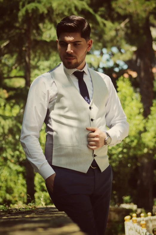 a man wearing a vest and tie, in the woods