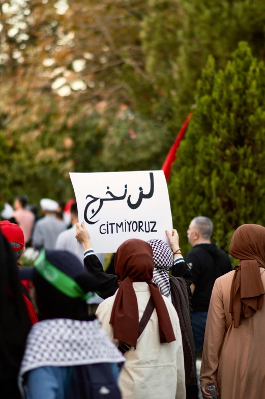 several people in hoodies are carrying signs