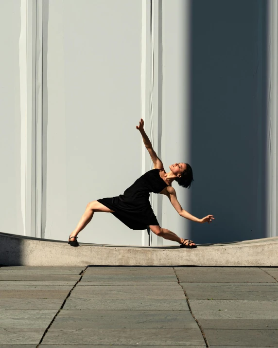 a woman is standing on a ledge and stretching