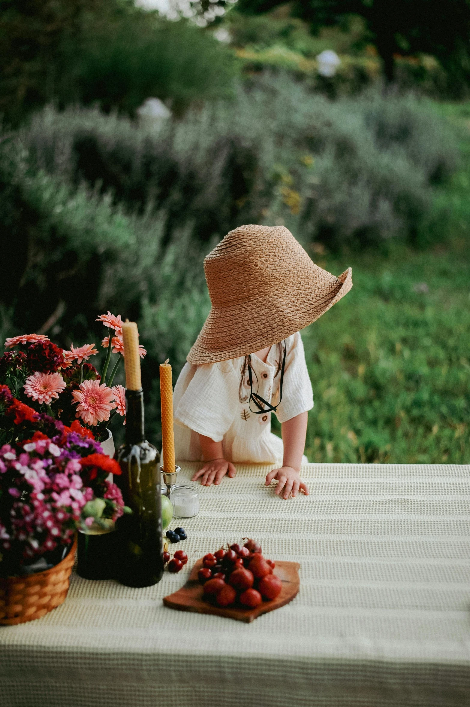 a young child sitting on a table with flowers