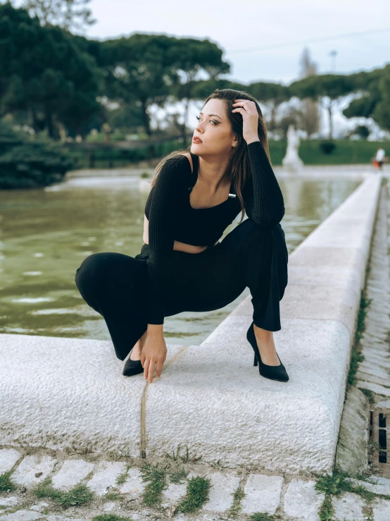 a beautiful young woman posing on the ledge