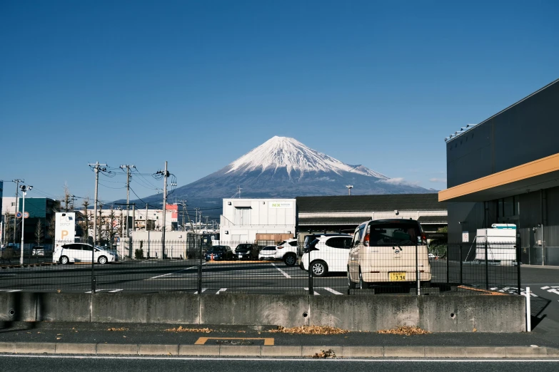 trucks parked at the side of a road with a large mountain in the background