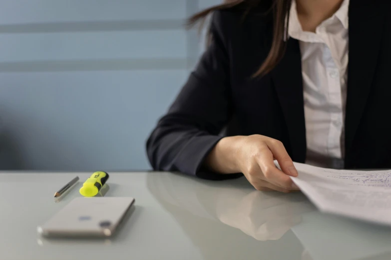 woman sitting at desk with note and pen