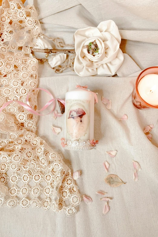 a close up of some candles and lacy material on a bed