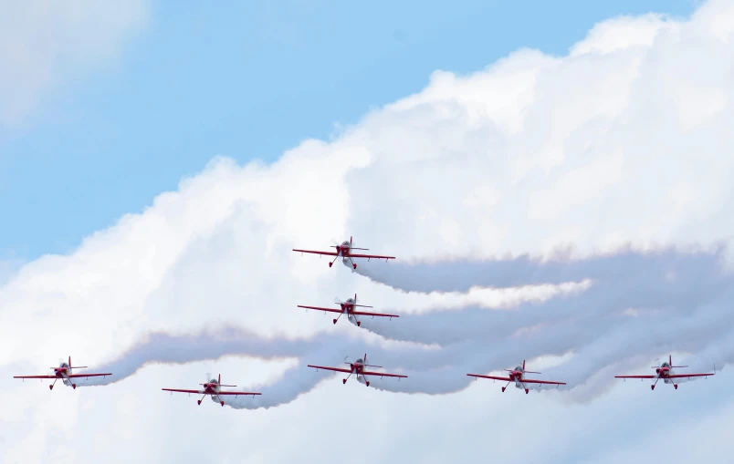 six planes are in the sky with smoke trailing