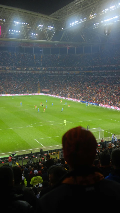 a crowded stadium with a group of people playing soccer