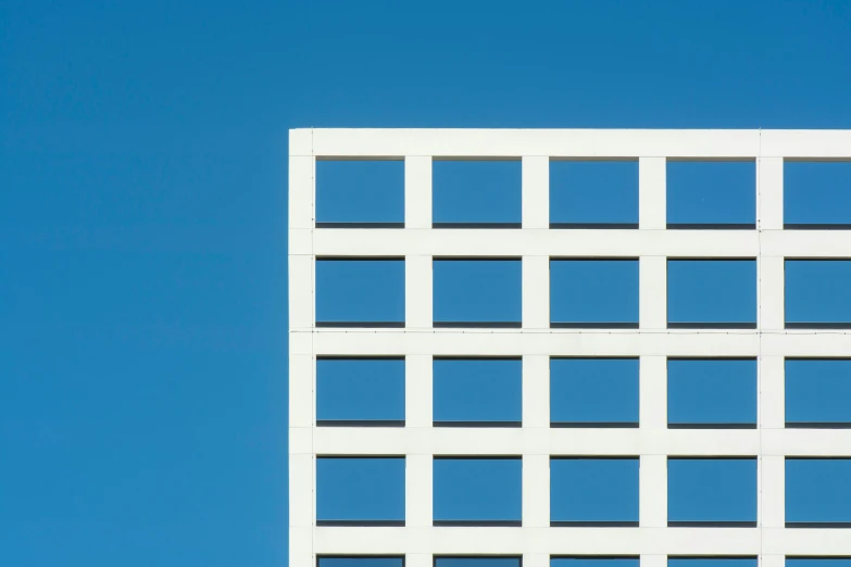 the window facade of an office building with a plane in the background