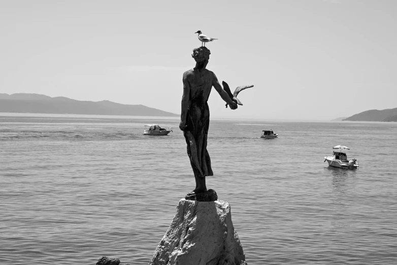 black and white po of a statue near the ocean