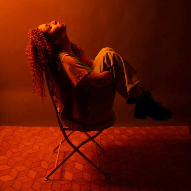 a young woman is sitting in a chair looking up