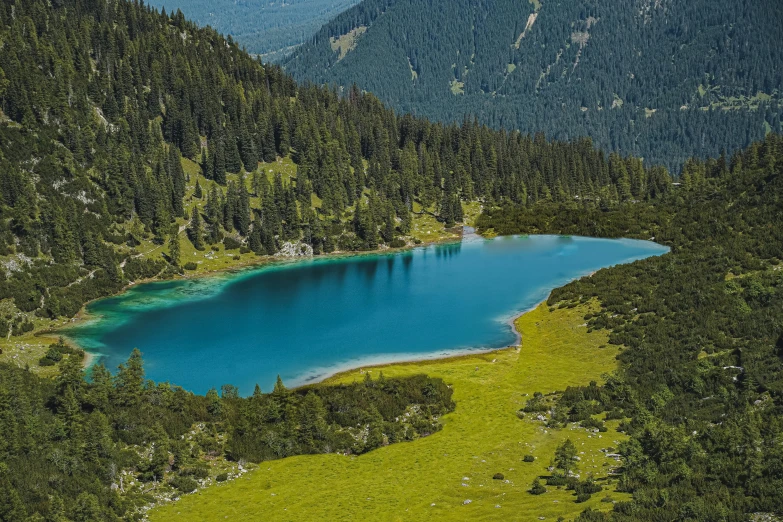 a lake is surrounded by a wooded hill