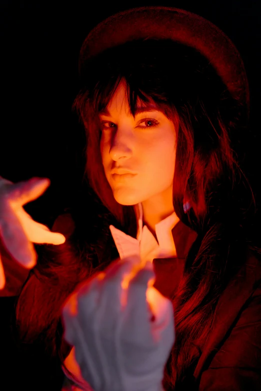 a woman in a top hat is holding a lit candle