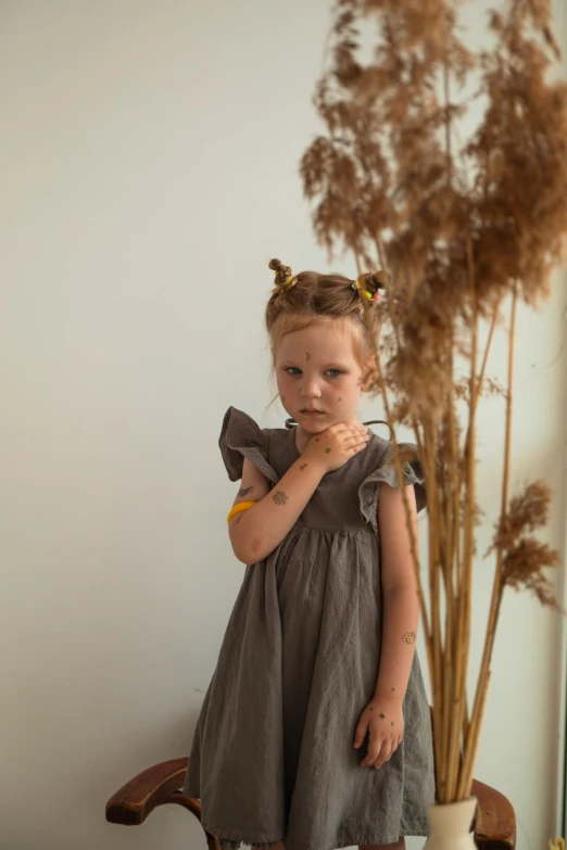 the little girl is standing near some plants