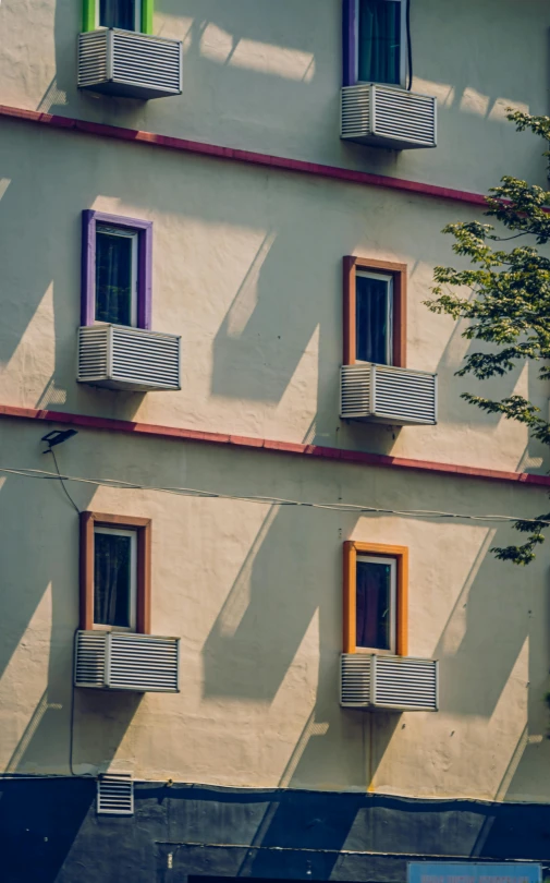 windows with shutters are hanging outside of a building