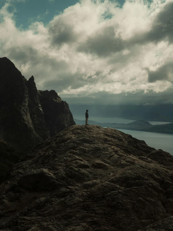 an aerial view of mountains with the person standing at the top