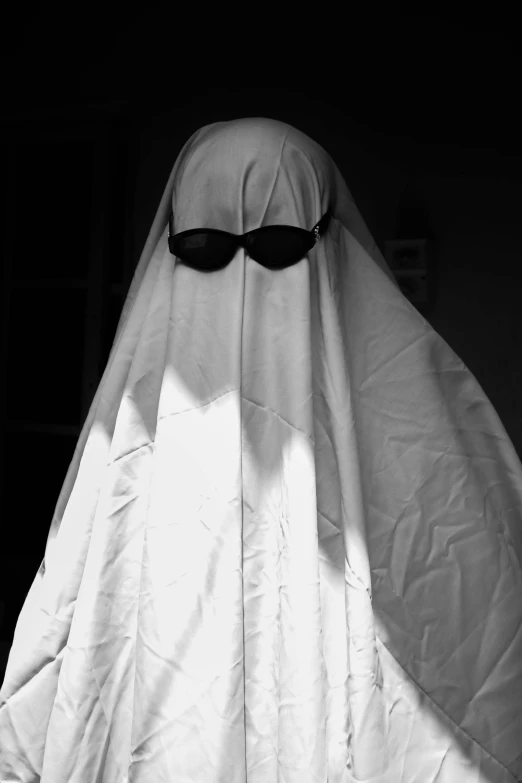 a white ghost with black sunglasses and a long white veil