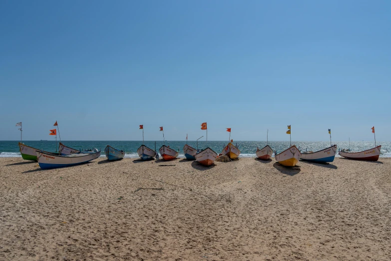 row boats sitting on the shore line of a beach