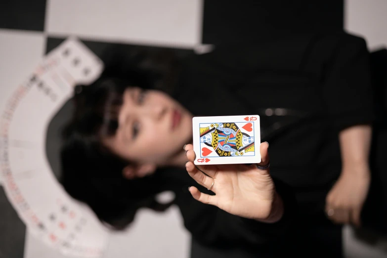 a woman holding a playing card next to another person