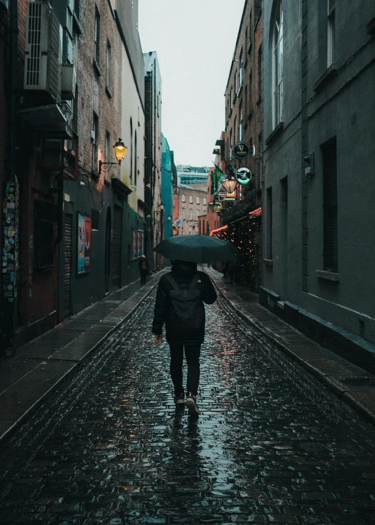 a person walking down a street in the rain