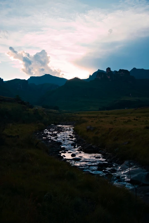 a body of water near some mountains at night