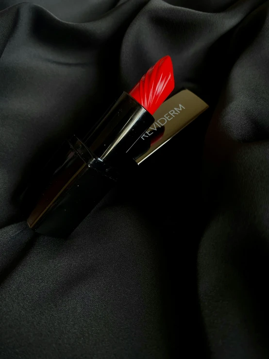 a lipstick with a red tip on top of it