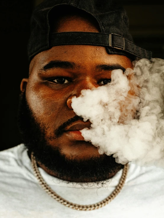 a man standing in front of a camera while smokes from his mouth