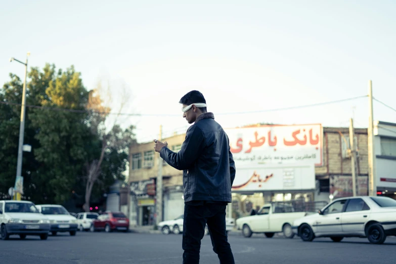 a man standing on the road and talking on his cell phone