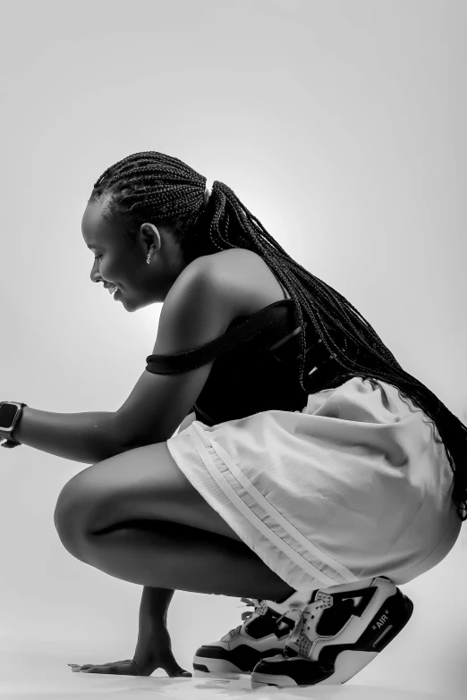 a woman kneeling down in front of a white wall