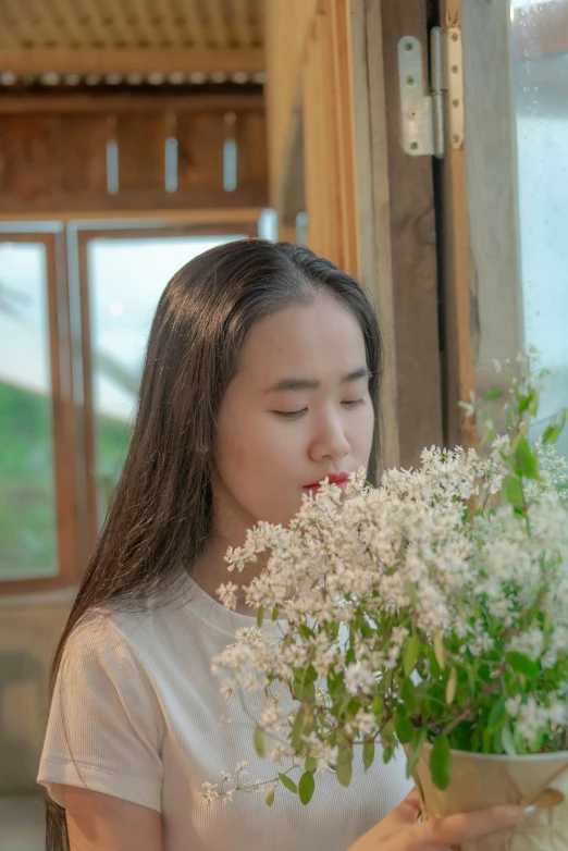 a woman holds some white flowers as she smiles