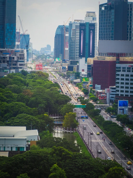 a busy city street with tall buildings, many cars, and people