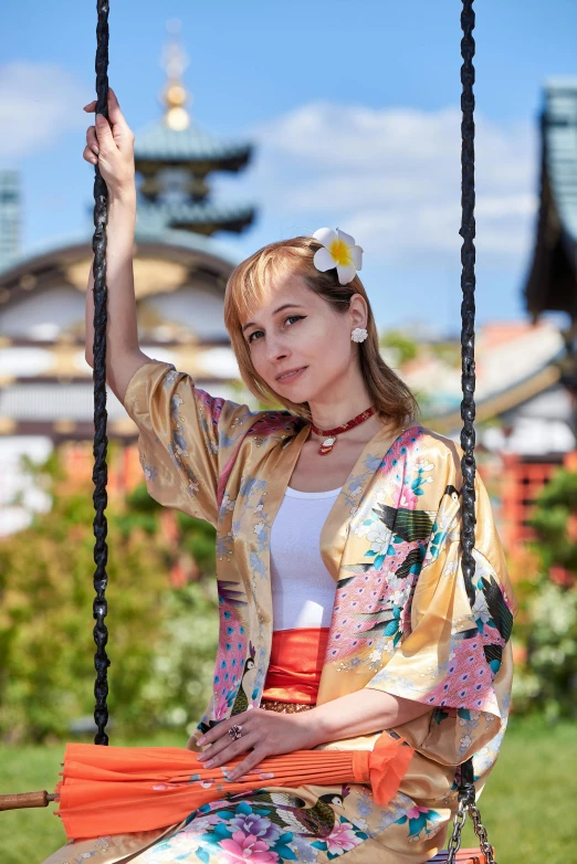 a beautiful woman sitting on top of a swing