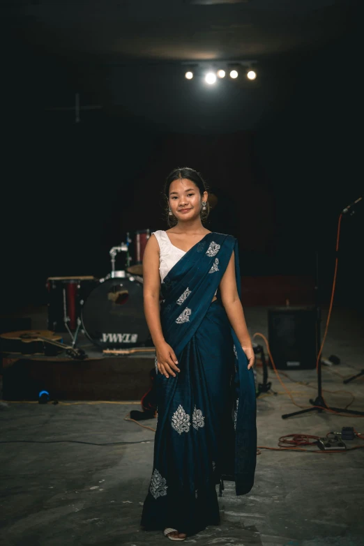 a woman wearing a blue saree while standing