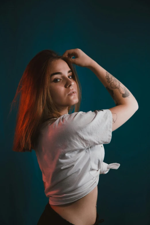 a young woman with red hair posing in front of a blue background