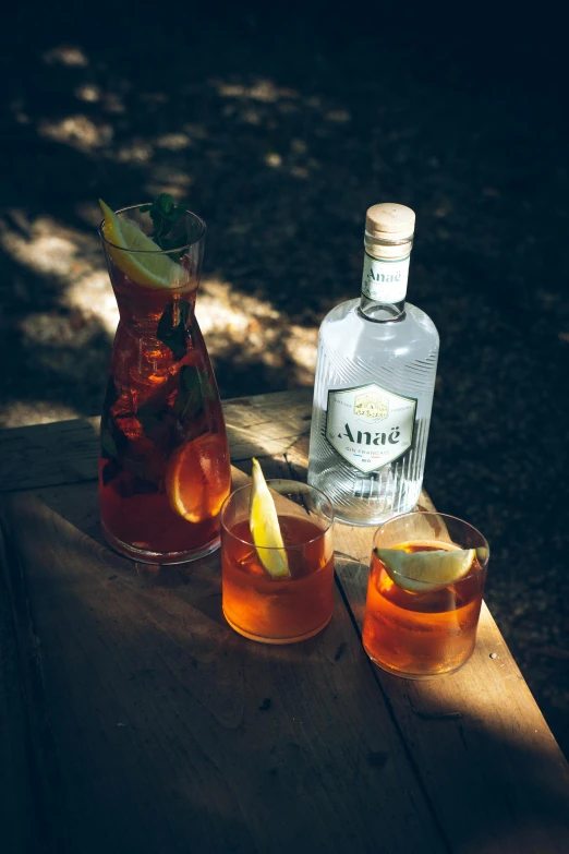 a wooden table with three glasses filled with drinks