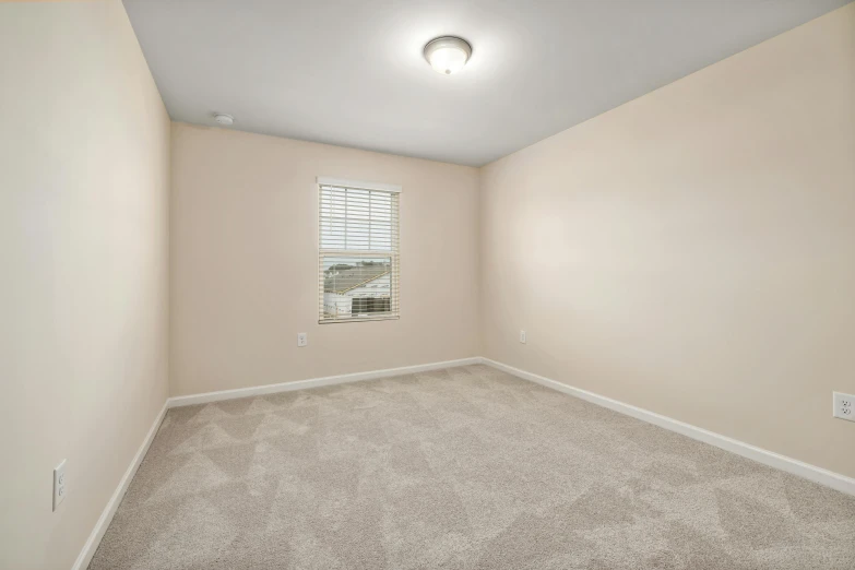 this bedroom is empty and has an oval window