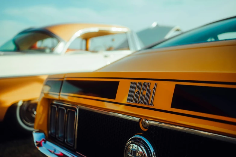 the front of a vintage yellow car with its license plate