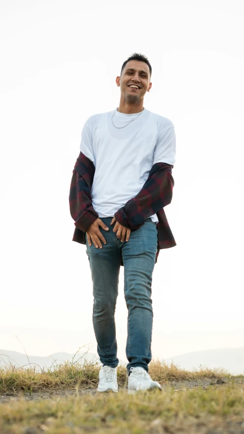 a man standing on top of a grass covered field