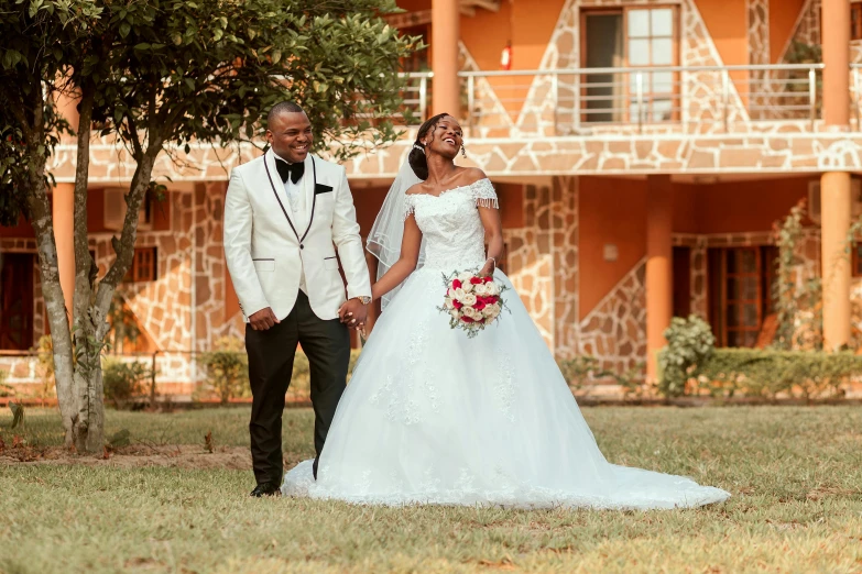 a bride and groom stand in front of the resort