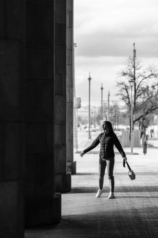 a person standing under an arch with another person walking