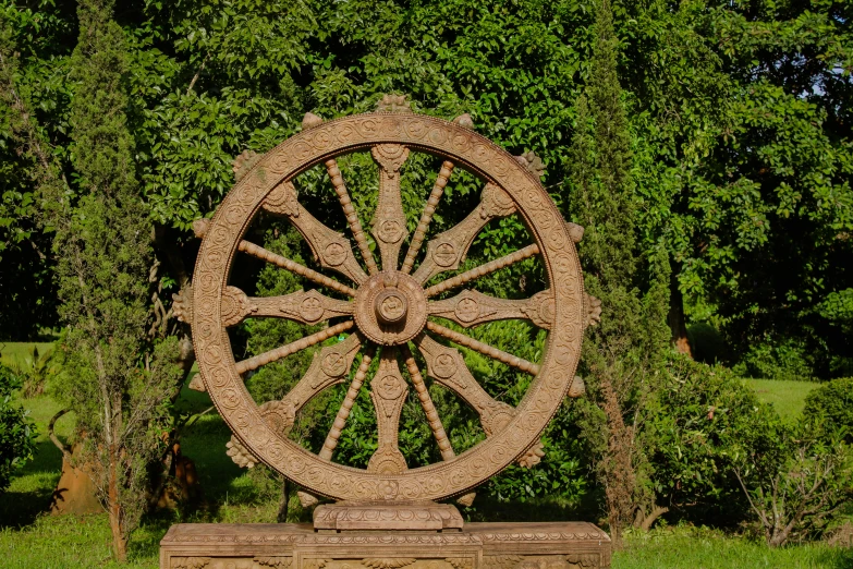 a rusty wheel that is sitting in the grass