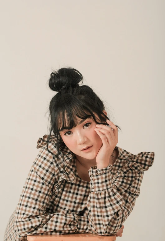 an asian woman is sitting at a wooden table