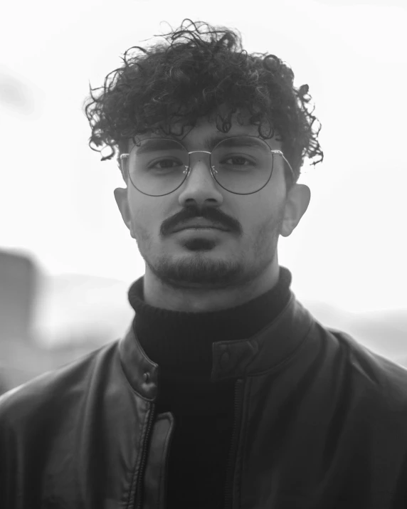 a black and white pograph of a man with glasses