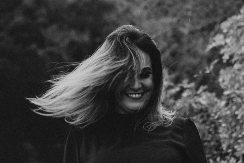 black and white pograph of woman's long hair blowing in the wind
