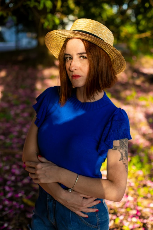 a woman in a straw hat poses for a pograph